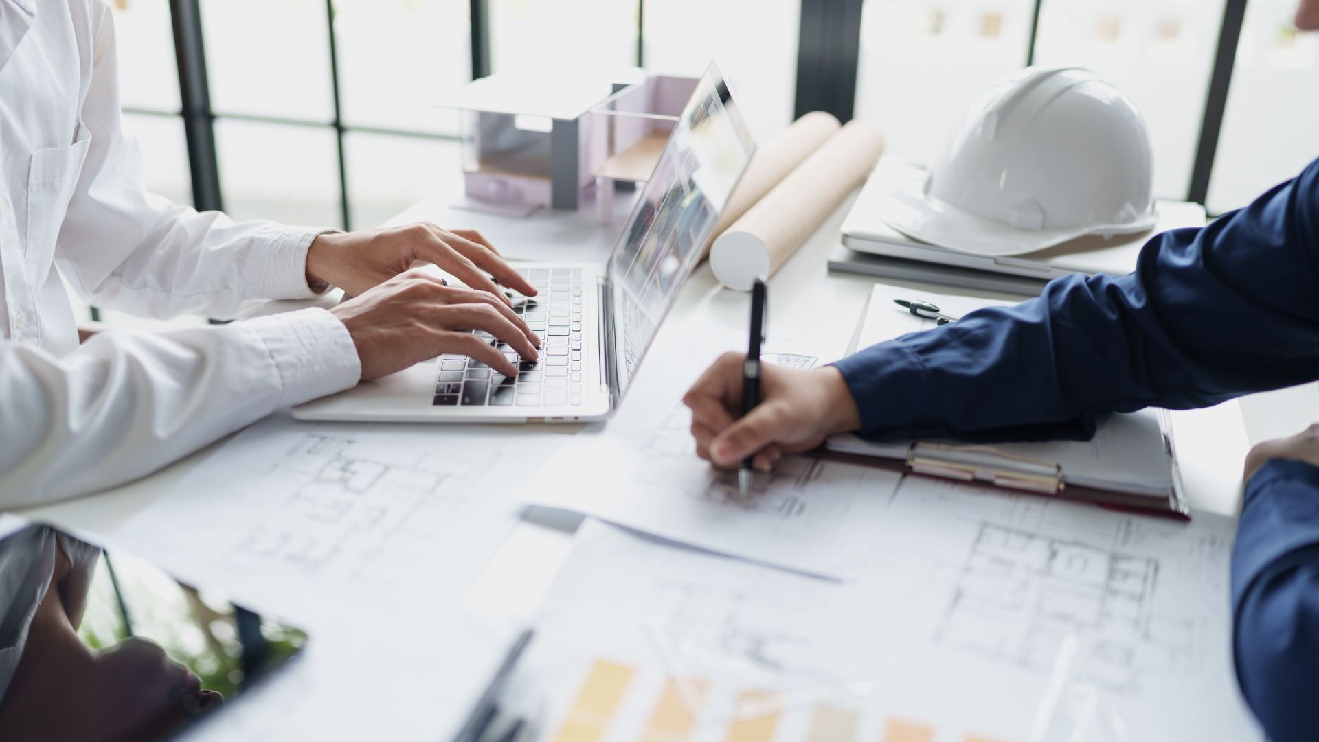 Equipa de engenharia a trabalhar sobre desenhos de projeto